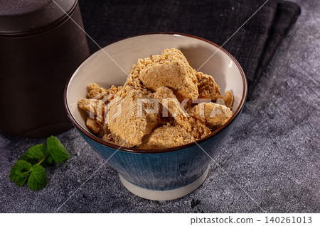 Bowl of textured soy protein chunks on dark stone background 140261013