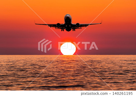 Passenger aircraft landing over the sea against the backdrop of scenic sunset 140261195