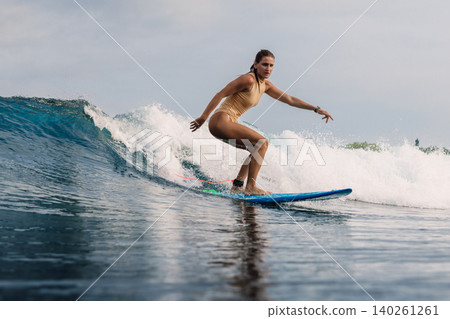 Female surfer on surfboard during surfing. Surfer woman on ocean wave Female surfer on surfboard during surfing. Surfer woman on ocean wave 140261261