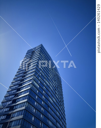 Modern glass skyscraper rising into a clear blue sky 140261429