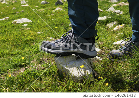 Hiking boots firmly stepping onto a rock in the Austrian Alps, highlighting connection with nature through physical activity Hiking boots firmly stepping onto a rock in the Austrian Alps, highlighting connection with nature through physical activity 140261438