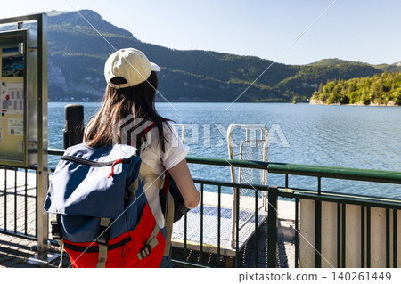 Woman standing on a pier at Lake Wolfgangsee in the Austrian Alps, reflecting seasonal adventure and an active outdoor lifestyle Woman standing on a pier at Lake Wolfgangsee in the Austrian Alps, reflecting seasonal adventure and an active outdoor lifestyle 140261449