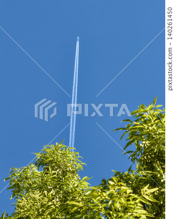 Airplane leaving twin contrails in a clear blue sky Airplane leaving twin contrails in a clear blue sky 140261450