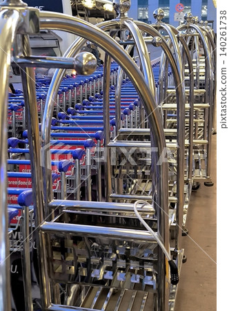 A row of metal luggage carts at an airport or hotel A row of metal luggage carts at an airport or hotel 140261738