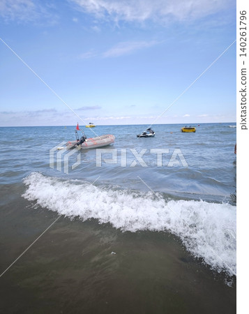An inflatable motorboat and a jet ski on the sea waves beneath a cloudy sky An inflatable motorboat and a jet ski on the sea waves beneath a cloudy sky 140261796