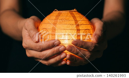 Close Up of Hands Holding Glowing Paper Lantern Close Up of Hands Holding Glowing Paper Lantern 140261993
