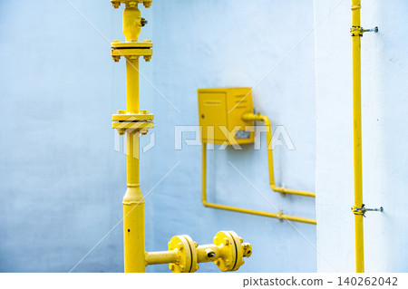 A Close-Up View of Bright Yellow Industrial Pipes and Accessories Against a Clean Wall, Highlighting the Functional Aesthetics of Utility Design A Close-Up View of Bright Yellow Industrial Pipes and Accessories Against a Clean Wall, Highlighting the Functional Aesthetics of Utility Design 140262042