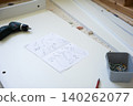 Electric drill and assembly instructions on white surface with screws and tools nearby 140262077