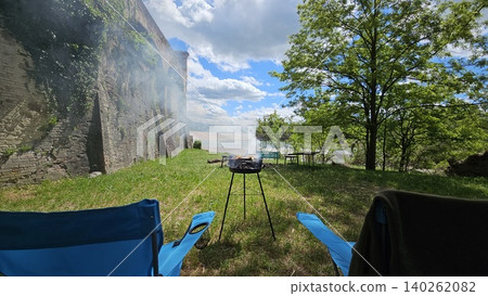 Folding chairs next to barbecue on a sunny day at a picnic by the river Folding chairs next to barbecue on a sunny day at a picnic by the river 140262082