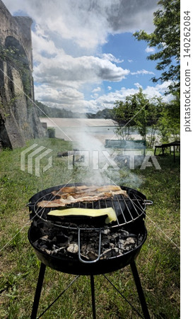 Close up view of barbecue smoking on a sunny day at a picnic by the river Close up view of barbecue smoking on a sunny day at a picnic by the river 140262084