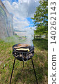 Vertical Image of barbecue smoking on a sunny day at a picnic by the river Vertical Image of barbecue smoking on a sunny day at a picnic by the river 140262143