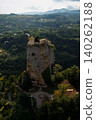 A solitary, enormous rock: the Katskhi Pillar. The monastery sits atop a cliff surrounded by trees. 140262188