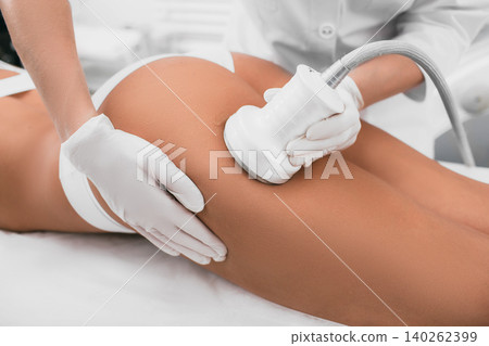 woman having cavitation procedure, cellulite treatment, on her buttocks and legs woman having cavitation procedure, cellulite treatment, on her buttocks and legs 140262399