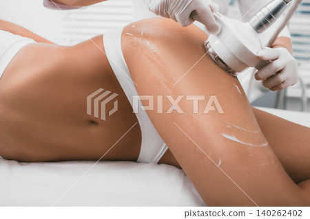 woman having cavitation procedure, cellulite treatment, on her buttocks and legs woman having cavitation procedure, cellulite treatment, on her buttocks and legs 140262402