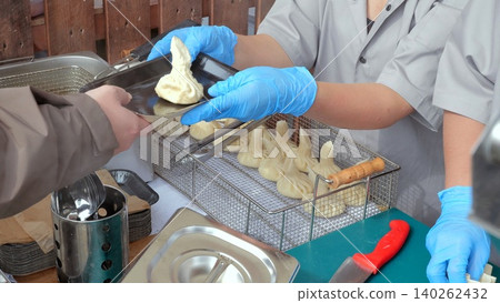 Kitchen station with precise cooking and presentation, Food vendor station highlighting skilled artisans assembling dumplings with professional tools and methodical 140262432