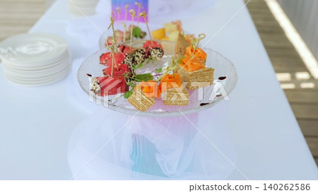 Gourmet mini appetizers combining salmon, ham, cheese, and waffles elegantly plated on transparent glassware, highlighting refined culinary craftsmanship at upscale gathering 140262586