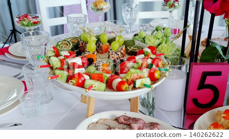Elegant catering banquet table displaying gourmet appetizers, prepared for wedding celebration with professional culinary presentation Elegant catering banquet table displaying gourmet appetizers, prepared for wedding celebration with professional culinary presentation 140262622
