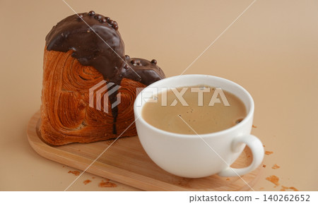 Latte cappuccino coffee drink with Delicious fresh croissant topped with Dark chocolate flavor Ganache. Creation unique heart shape bakery. Puff pastry holiday love gift present idea Valentine's day Latte cappuccino coffee drink with Delicious fresh croissant topped with Dark chocolate flavor Ganache. Creation unique heart shape bakery. Puff pastry holiday love gift present idea Valentine's day 140262652
