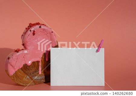 Empty paper note template sample mock up blank for wishes greeting holiday card Heartshaped pastry croissant treat topped with colorful frosting galore. Food experimentation viral dessert baking trend 140262680