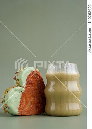 Green tea Matcha latte cappuccino beverage Morning breakfast gift idea Heart shaped pistachio croissant on green background with copy space. Puff pastry trendy sweet dessert bakery. Creamy dough Green tea Matcha latte cappuccino beverage Morning breakfast gift idea Heart shaped pistachio croissant on green background with copy space. Puff pastry trendy sweet dessert bakery. Creamy dough 140262693