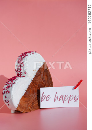 BE HAPPY message words on paper note Heart shaped white chocolate croissant on pink background with copy space. Puff pastry new trendy sweet dessert bakery. Creamy dough BE HAPPY message words on paper note Heart shaped white chocolate croissant on pink background with copy space. Puff pastry new trendy sweet dessert bakery. Creamy dough 140262712
