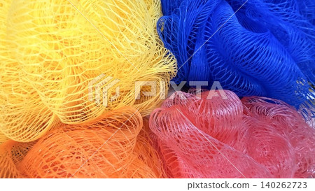 Colorful bath mesh sponges in close-up, bright textured background of cleaning accessories. 140262723