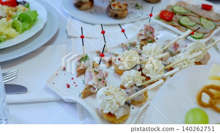 Catering professionals arranging elegant party appetizers, presenting diverse canapes featuring seafood, meats, cheeses, seasonal vegetables, fresh fruits for sophisticated event dining Catering professionals arranging elegant party appetizers, presenting diverse canapes featuring seafood, meats, cheeses, seasonal vegetables, fresh fruits for sophisticated event dining 140262751