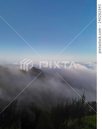 Peak emerging from a sea of clouds on Vereda do Pico Ruivo trail in Madeira Portugal Peak emerging from a sea of clouds on Vereda do Pico Ruivo trail in Madeira Portugal 140262843