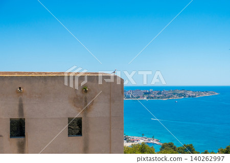 Seagull on Stone Building Wall with Sea and City in Background Seagull on Stone Building Wall with Sea and City in Background 140262997