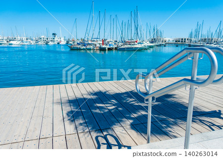 Accessible Metal Pier Railing with Harbor and Boats in Background 140263014