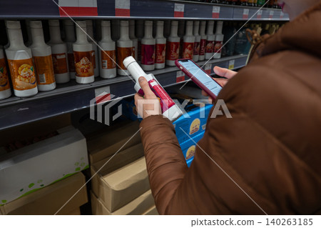 Home cook selecting condiment from supermarket shelf. Female shopper carefully picking sauce brand for dinner preparation. Woman in grocery store focusing on selecting perfect sauce for her meal plan Home cook selecting condiment from supermarket shelf. Female shopper carefully picking sauce brand for dinner preparation. Woman in grocery store focusing on selecting perfect sauce for her meal plan 140263185