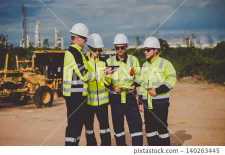 Engineers reviewing plans on tablet at oil and gas refinery site for inspection and management Engineers reviewing plans on tablet at oil and gas refinery site for inspection and management 140263445