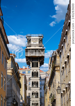 Iconic Santa Justa lift elevator in historic center of Lisbon, Portugal on sunny summer day with blue sky and some clouds. Iron tower, iconic city landmark, travel destination, heritage engineering Iconic Santa Justa lift elevator in historic center of Lisbon, Portugal on sunny summer day with blue sky and some clouds. Iron tower, iconic city landmark, travel destination, heritage engineering 140263600