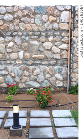 Garden Scene Description. Decorative Garden With Roses. Rustic Stone Wall Surrounded By Vibrant Roses. Colorful Blooming Roses Alongside Textured Masonry And Landscape Features Garden Scene Description. Decorative Garden With Roses. Rustic Stone Wall Surrounded By Vibrant Roses. Colorful Blooming Roses Alongside Textured Masonry And Landscape Features 140263667