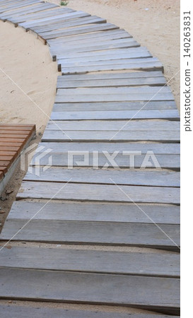 Old Wooden Trail Along Dunes. Weathered Wooden Footpath Beside Calm And Peaceful Beaches. Timeworn Wooden Promenade Running Alongside Serene And Tranquil Coastal Dunes Old Wooden Trail Along Dunes. Weathered Wooden Footpath Beside Calm And Peaceful Beaches. Timeworn Wooden Promenade Running Alongside Serene And Tranquil Coastal Dunes 140263831