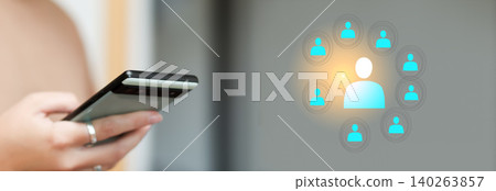 Manager using smartphone for HR recruitment and team management with network interface. Wide panoramic banner of person holding mobile phone with glowing blue human resource icons and large copy space Manager using smartphone for HR recruitment and team management with network interface. Wide panoramic banner of person holding mobile phone with glowing blue human resource icons and large copy space 140263857