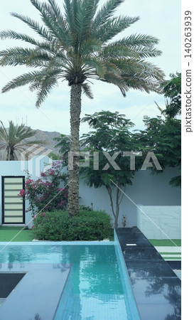 Tranquil Luxurious Oasis. Serene Blue Pool Adorned By Tropical Greenery And Privacy Features. Contemporary Swimming Area Surrounded By Verdant Plants And Stylish Fencing Tranquil Luxurious Oasis. Serene Blue Pool Adorned By Tropical Greenery And Privacy Features. Contemporary Swimming Area Surrounded By Verdant Plants And Stylish Fencing 140263939
