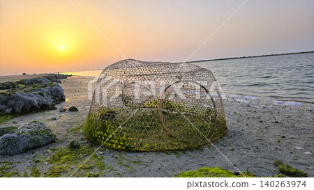 Tranquil Seaside Scene. Calm Shoreline With Fishing Nets. Serene Coastal View With Seaweed And Trap. Quiet Beach Setting Featuring Fishing Apparatus And Coastal Serenity 140263974
