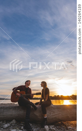 Friends Making Music by the River at Sunset Friends Making Music by the River at Sunset 140264189