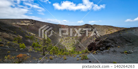 The crater of the San Antonio volcano on the Canary Island of La Palma with a growth of trees and small shrubs in it on black volcanic soil and solidified lava. High quality photo The crater of the San Antonio volcano on the Canary Island of La Palma with a growth of trees and small shrubs in it on black volcanic soil and solidified lava. High quality photo 140264263