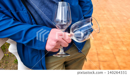 The man is holding two wine glasses in his hand for tasting. High quality photo 140264331
