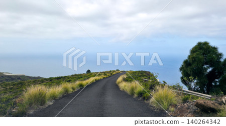 Scenic winding road through lush green landscape with volcanic rock formations under cloudy sky in mountainous region. High quality photo Scenic winding road through lush green landscape with volcanic rock formations under cloudy sky in mountainous region. High quality photo 140264342
