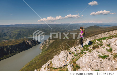 Woman Hiking above River Canyon in Mountains Woman Hiking above River Canyon in Mountains 140264392