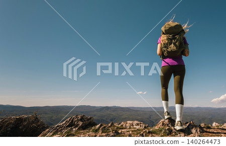 Female Explorer with Tourist Backpack Standing on Mountain Female Explorer with Tourist Backpack Standing on Mountain 140264473