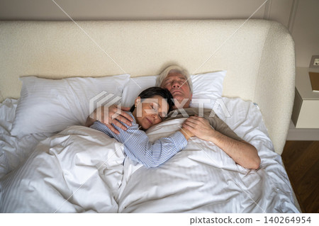 Trust, love and closeness in elderly relationships, senior man and woman embracing while sleeping Trust, love and closeness in elderly relationships, senior man and woman embracing while sleeping 140264954