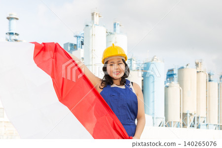 National flag of Indonesia in the hands of girl in overalls against background of modern metallurgical plant National flag of Indonesia in the hands of girl in overalls against background of modern metallurgical plant 140265076