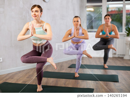 Group of women practice the eagle pose Group of women practice the eagle pose 140265194