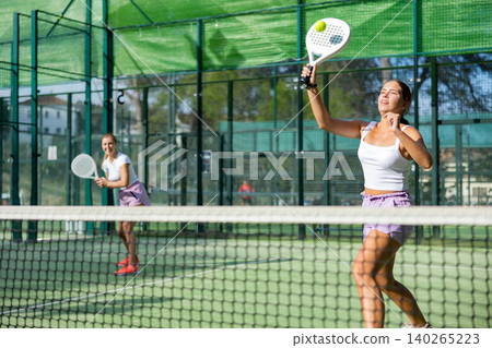 Padel game - woman with partners plays on tennis court Padel game - woman with partners plays on tennis court 140265223