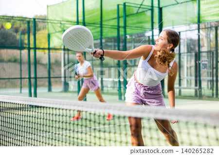 Young woman padel tennis player trains on the outdoor court Young woman padel tennis player trains on the outdoor court 140265282