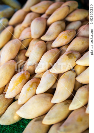 Bunch of exotic ripe Thai mango fruits selling at vendor stall at street food market in Thailand. Bunch of exotic ripe Thai mango fruits selling at vendor stall at street food market in Thailand. 140265339